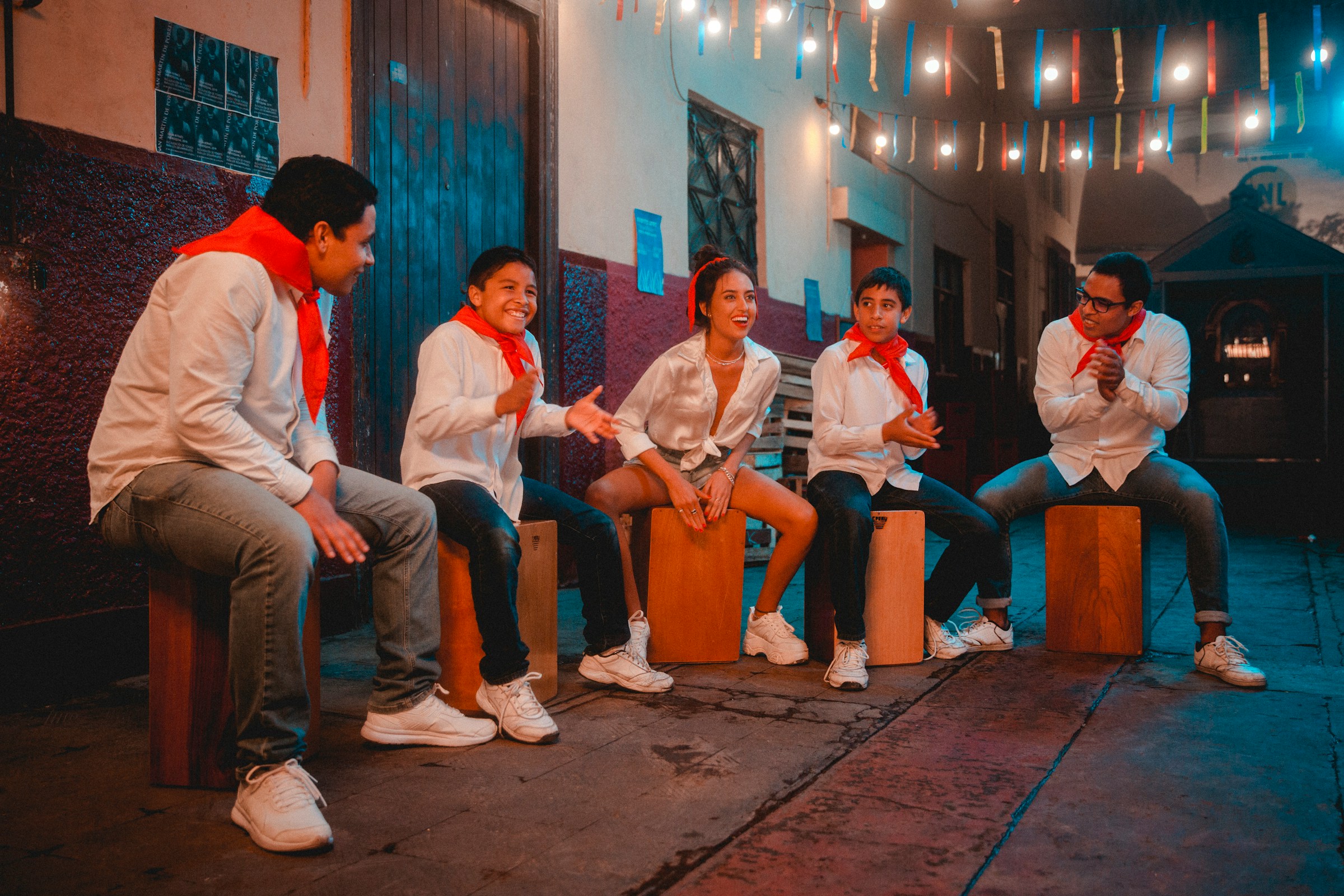 A group of people sitting on top of a wooden box.