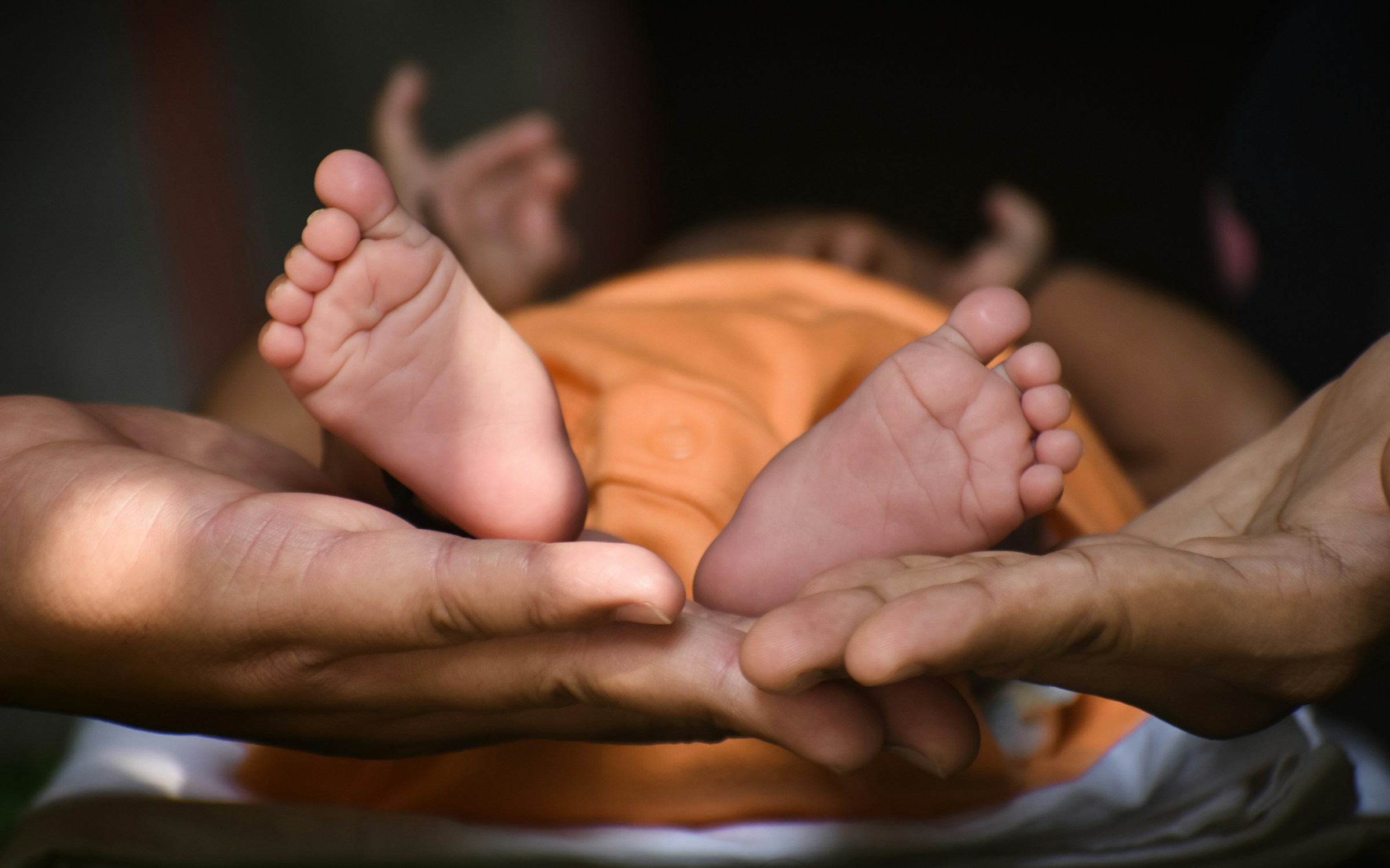 Person holding baby's feet.
