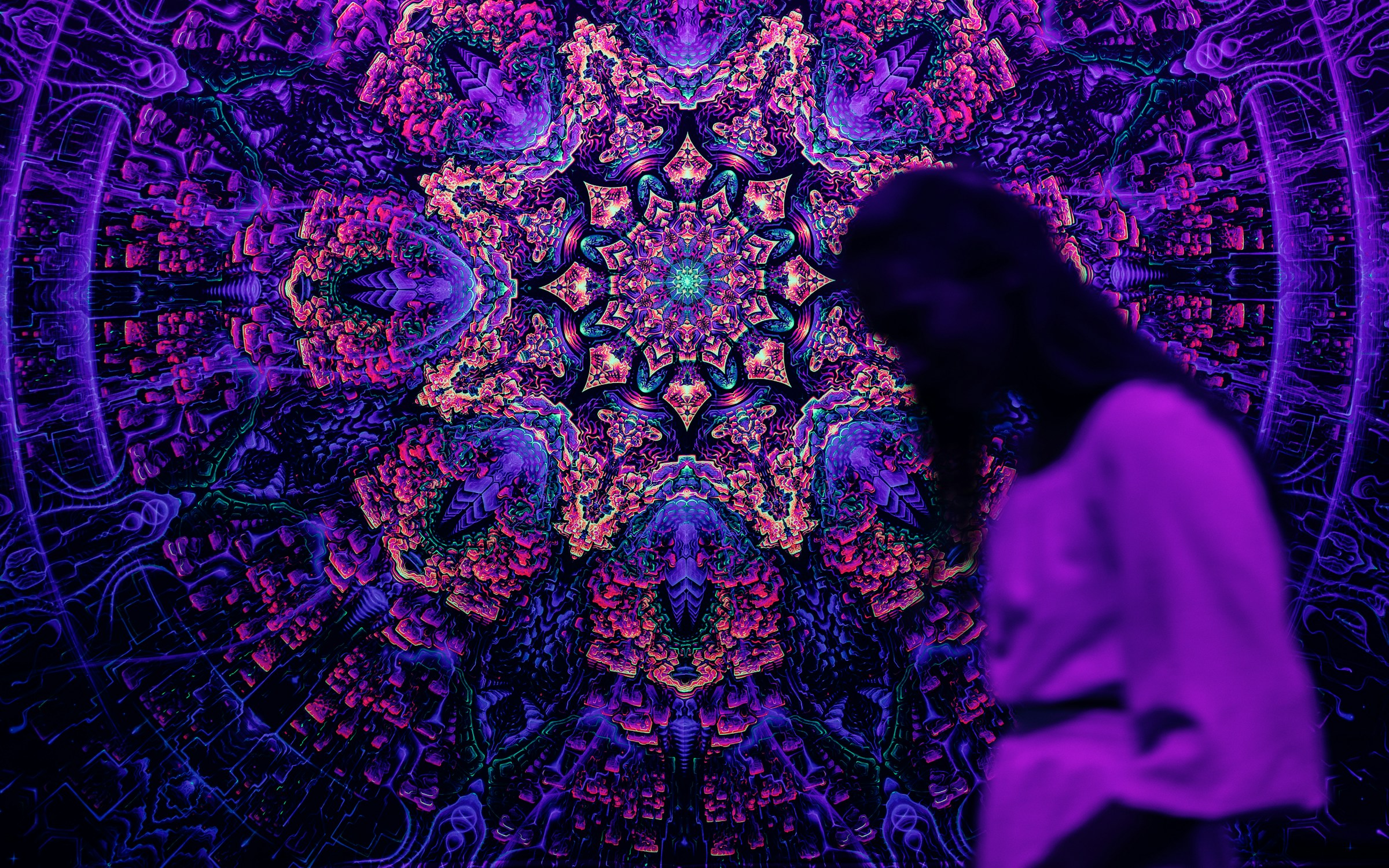 Female figure observing kaleidoscopic design.